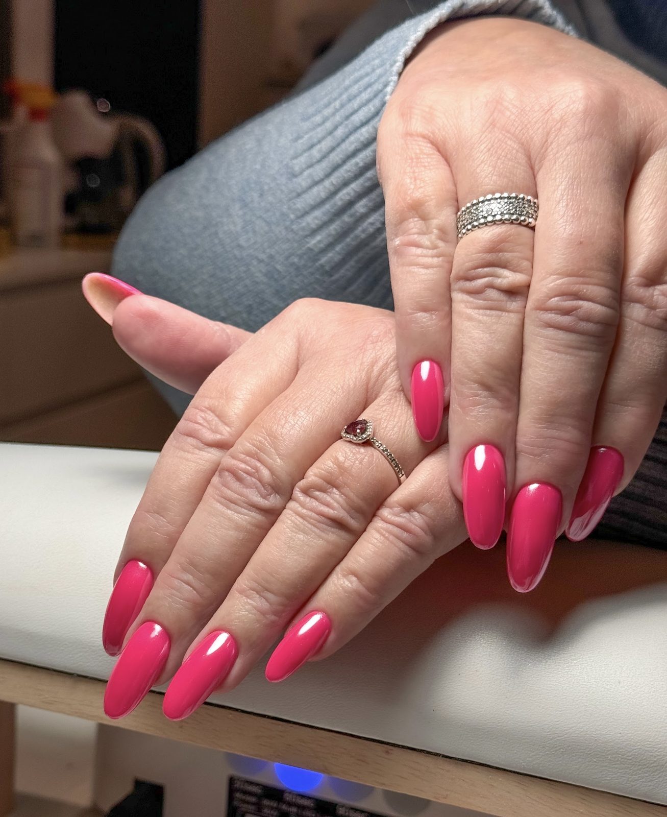 Felroze amandelvormige nagels op het behandelkussen